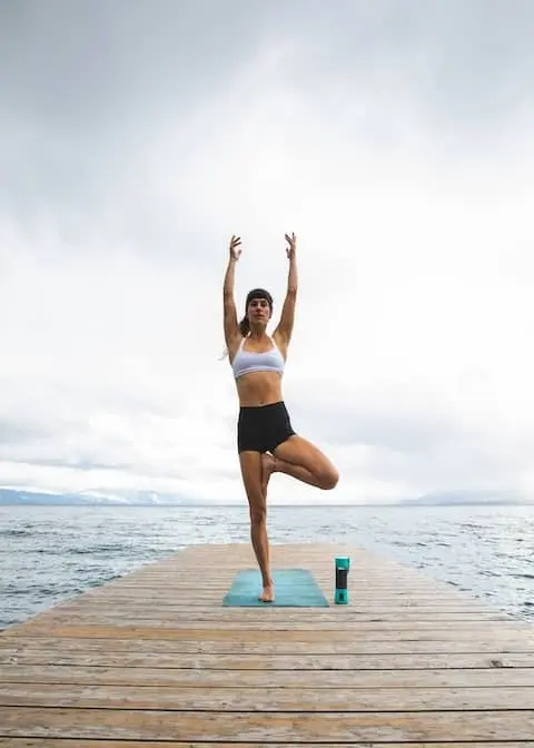 A woman doing yoga on a pier